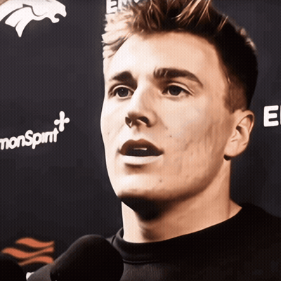 Man Talking Into Microphone In Front Of Monsprint Banner GIF