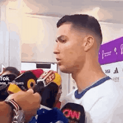 Man Talking Into Microphone In White Shirt GIF