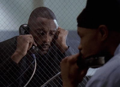 Man Talking On Cell Phone Behind Fence GIF