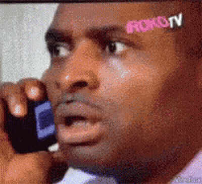 Man Talking On Cell Phone With Roku TV Sticker On Forehead GIF