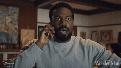 Man Talking On Cell Phone With Wonder Man Shirt GIF