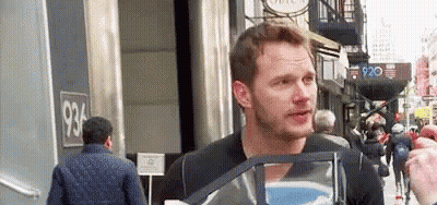 Man Talking To Another Man Holding Bag On City Street GIF