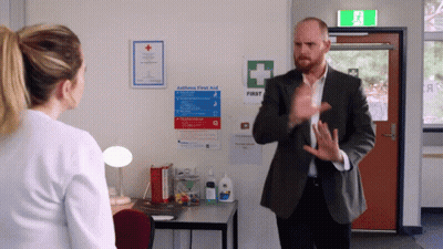 Man Talking To Woman In Front Of First Aid Sign GIF