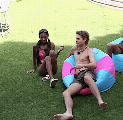 Man Talking To Woman On Pink And Blue Bean Bag Chair GIF
