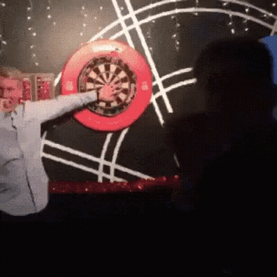 Man Throwing Dart At Red Rim Dart Board GIF