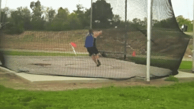 Man Throwing Frisbee In Field Behind Net GIF