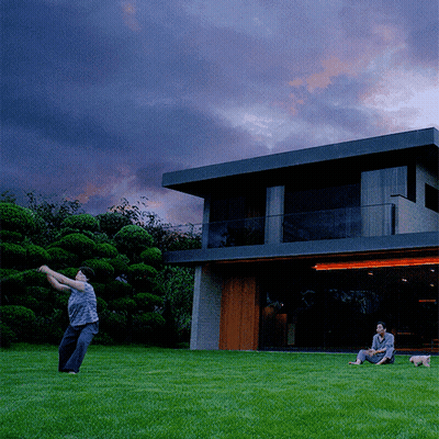 Man Throwing Frisbee In Front Of Large House GIF