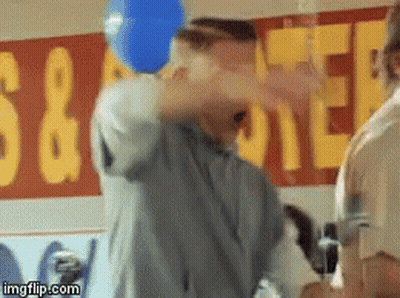 Man Throws Blue Balloon In Front Of S & A Coffee Sign GIF