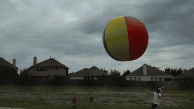 Man Throws Frisbee At Beach Ball GIF