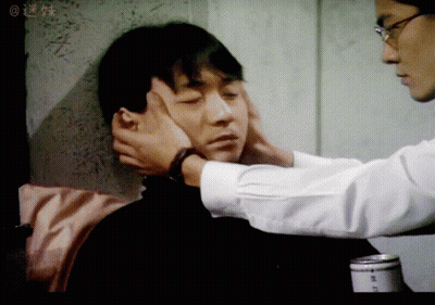 Man Touching Another Man's Face In Blurry Photo With Chinese Writing GIF