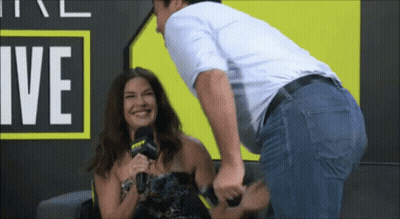 Man Touching Woman's Butt In Front Of Sign GIF