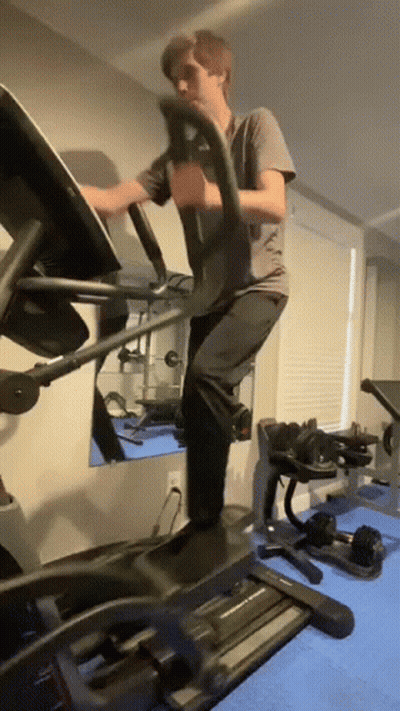 Man Using Elliptical Machine In Gym GIF