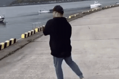 Man Walking Along Dock By Water GIF