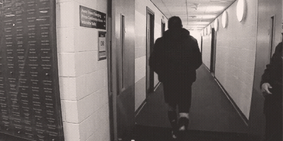 Man Walking Down Hallway With Intensive Suite Sign GIF