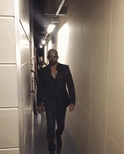 Man Walking Down Hallway With Sunglasses GIF