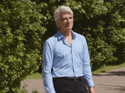 Man Walking Down Path Blue Shirt Black Pants GIF