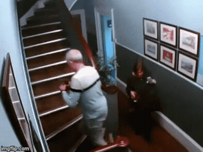 Man Walking Down Stairs While Woman Sits On Chair GIF