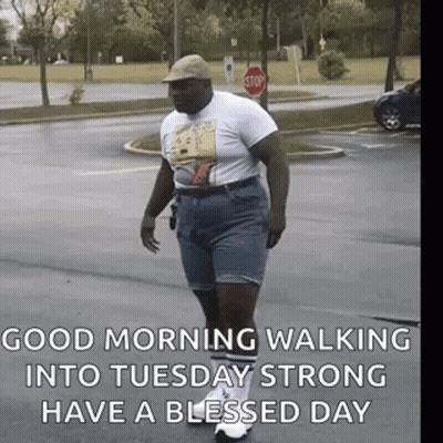 Man Walking Down Street In Hat And Shorts GIF