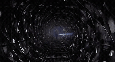 Man Walking Down Train Tracks In Dark Tunnel GIF