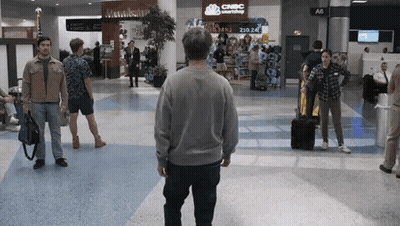 Man Walking In Airport With CNBC Smartshop On Wall GIF