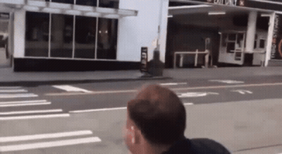 Man Walking In Front Of Exit Only Gas Station GIF