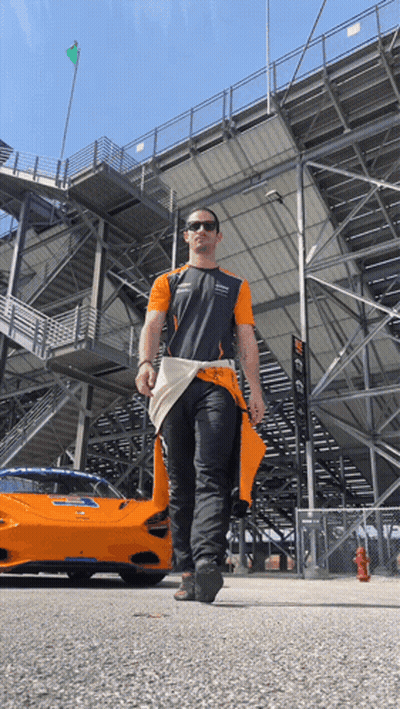 Man Walking In Front Of McLaren Race Car GIF