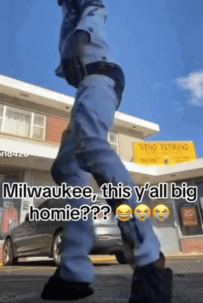 Man Walking In Front Of Milwaukee Building GIF