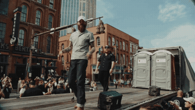 Man Walking In Front Of Whiskey Building GIF