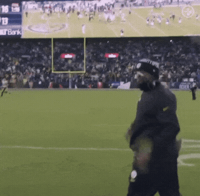 Man Walking On Football Field With Bank Screen GIF