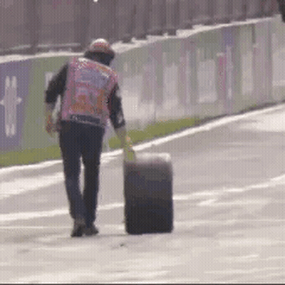 Man Walking On Race Track With Tire GIF