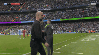 Man Walking On Soccer Field In Front Of Etihad Stadium Sign GIF