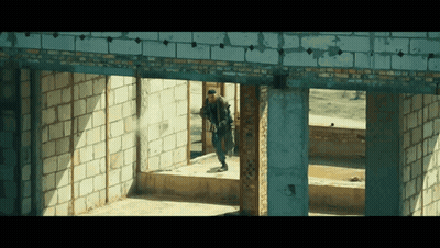 Man Walking Through Brick Building GIF