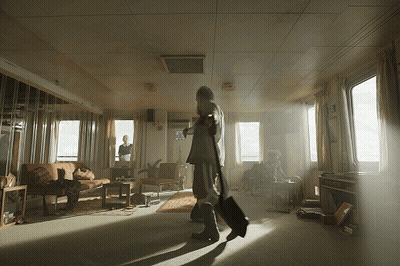 Man Walking Through Living Room With Woman On Couch GIF