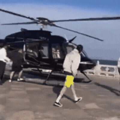 Man Walking Towards Helicopter In Yellow Shirt GIF