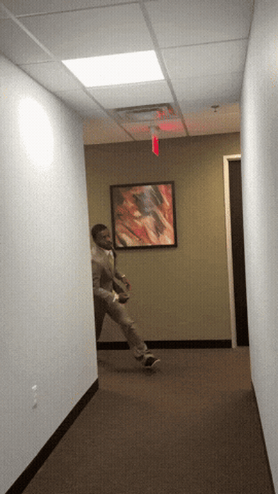 Man Walking Under Red Exit Sign GIF