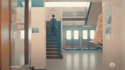Man Walking Up Stairs In School Hallway GIF