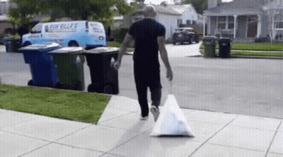 Man Walking With Trash Bag GIF
