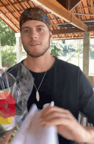 Man Wearing Bandana And Necklace Holding Bag Of Food GIF