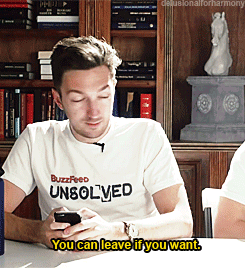 Man Wearing Buzzfeed Unsolved T-Shirt Looks At Phone GIF