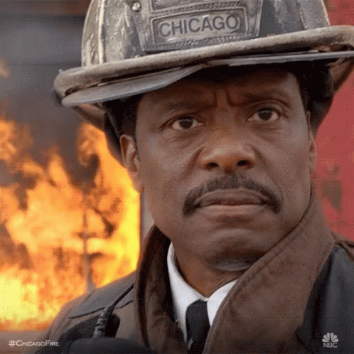 Man Wearing Chicago Fireman's Helmet Standing In Front Of Fire GIF