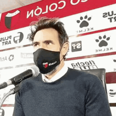 Man Wearing Face Mask Talking Into Microphone GIF