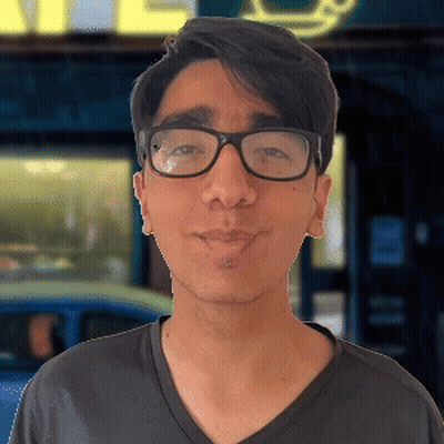 Man Wearing Glasses And Black Shirt In Front Of Cafe Sign GIF