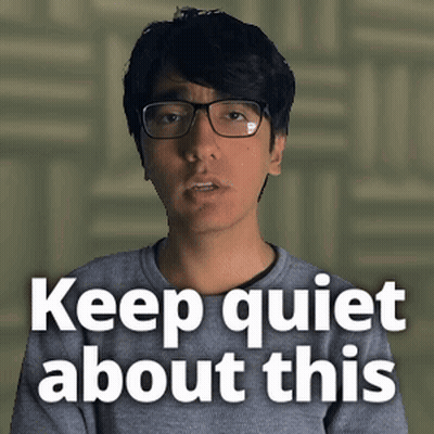 Man Wearing Glasses And Grey Shirt Says Keep Quiet GIF