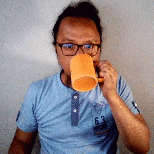 Man Wearing Glasses Drinking From Orange Cup GIF