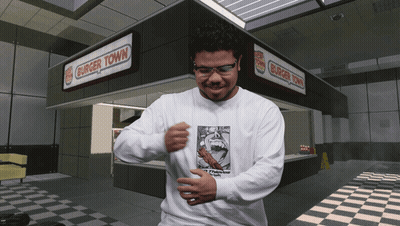 Man Wearing Glasses In Front Of Burger Town GIF