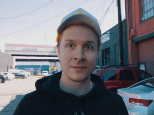 Man Wearing Hat And Black Hoodie In Front Of Abercrombie Building GIF