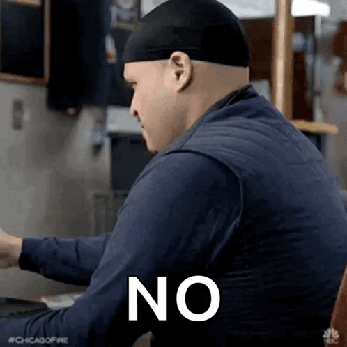 Man Wearing Hat And Blue Shirt Sitting At Table With Word No GIF