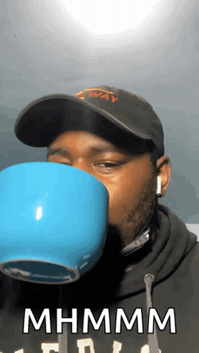Man Wearing Hat And Headphones Drinking Mhm Mhm Cup GIF