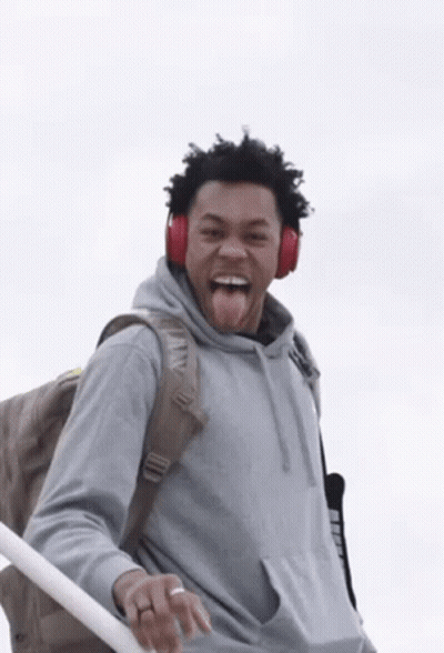 Man Wearing Headphones And Backpack Sticking Tongue Out GIF