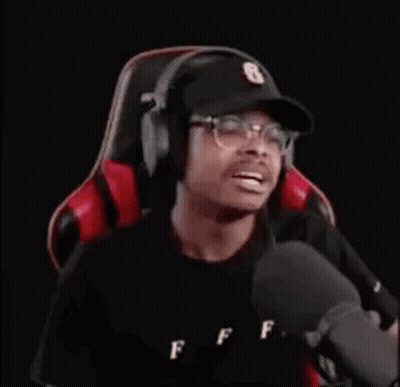 Man Wearing Headphones And Hat Sitting In Gaming Chair GIF